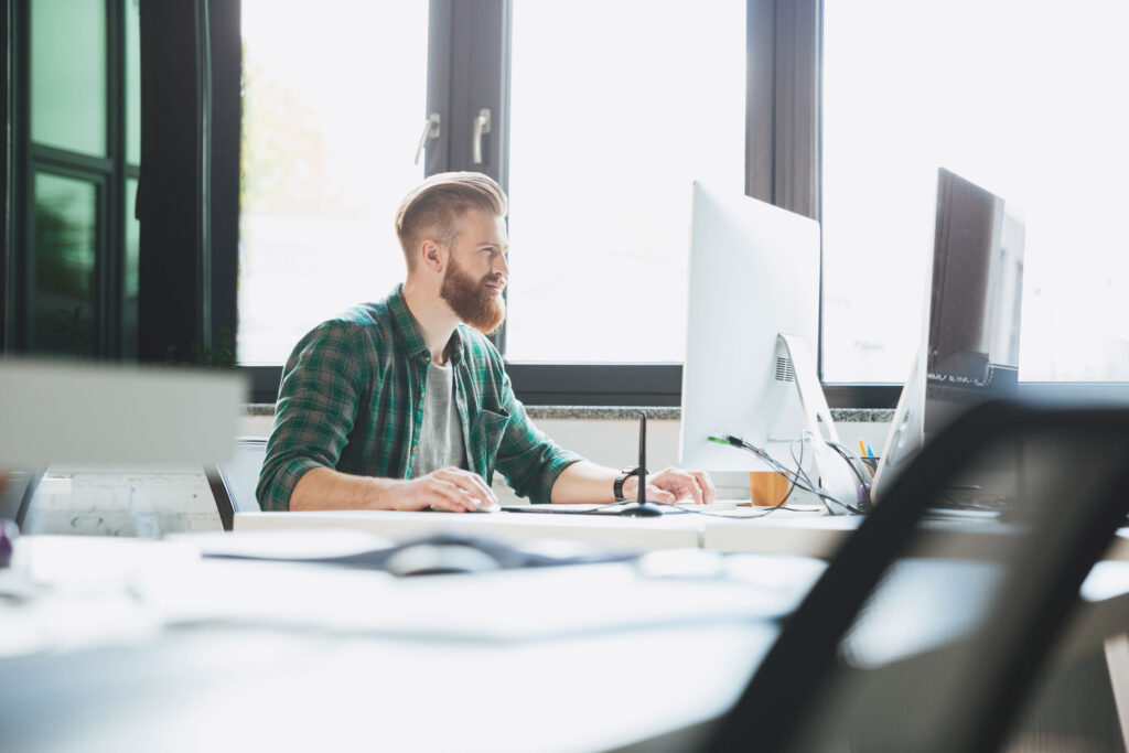 Programista pracujący przy komputerze w nowoczesnym biurze